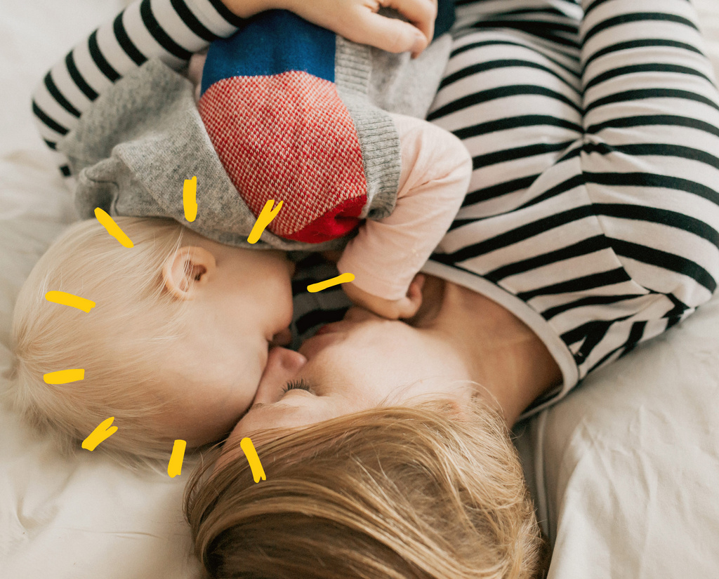 cute baby and mother cuddling on bed sunshine