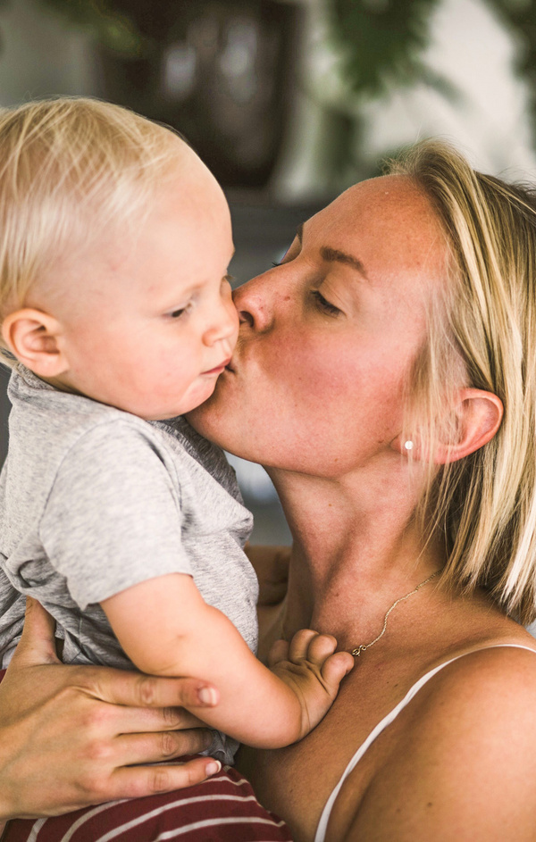 mom kissing her baby 