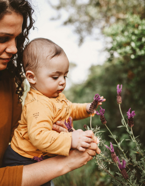 baby plucking flowers with mom