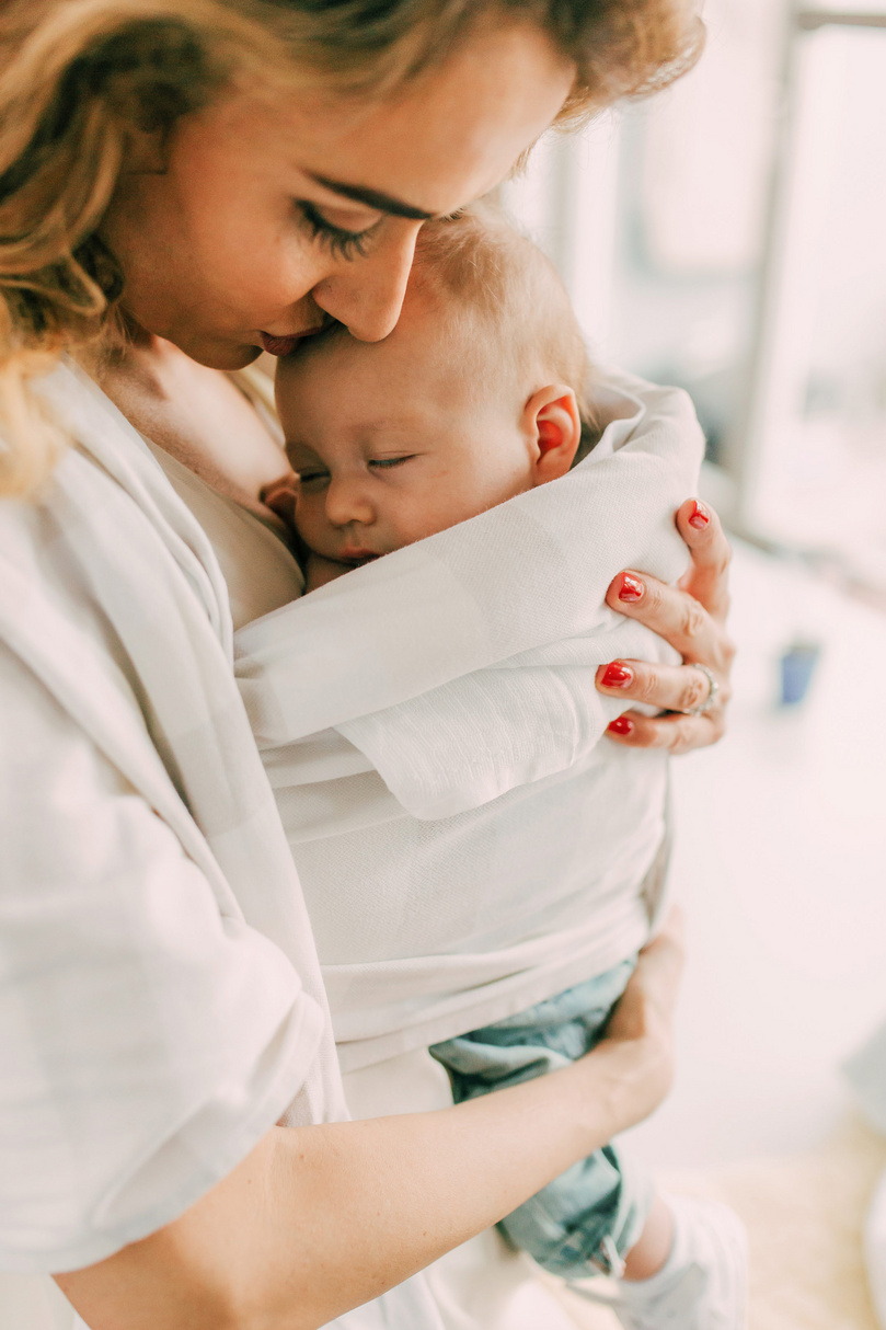 madre compartiendo amor al abrazar al bebé