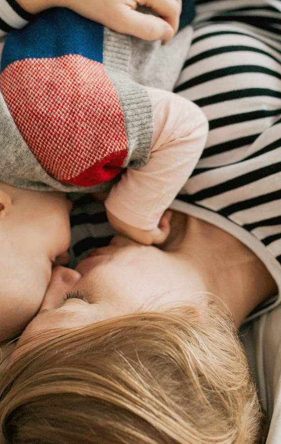 cute baby and mother cuddling on bed