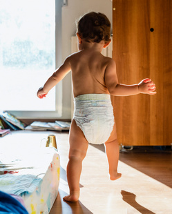 baby walking in diapers