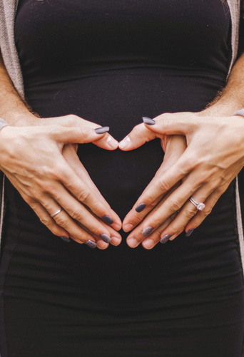 Embarazada con su marido sujetando la barriga