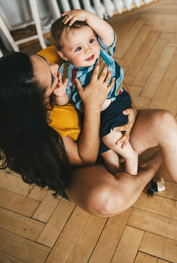 MAdre mirando a su bebe sujetandolo