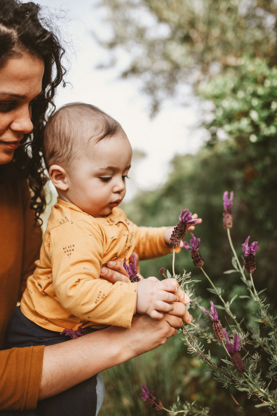 bebé cogiendo flores con mamá en el parque